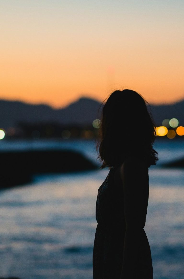 Leichtigkeit zurückholen Coaching nach Trennung und Krise Bild von einer Frau, die lachend im Gras liegt - Sinnbild für Leichtigkeit und Loslassen Maria Wadenpohl